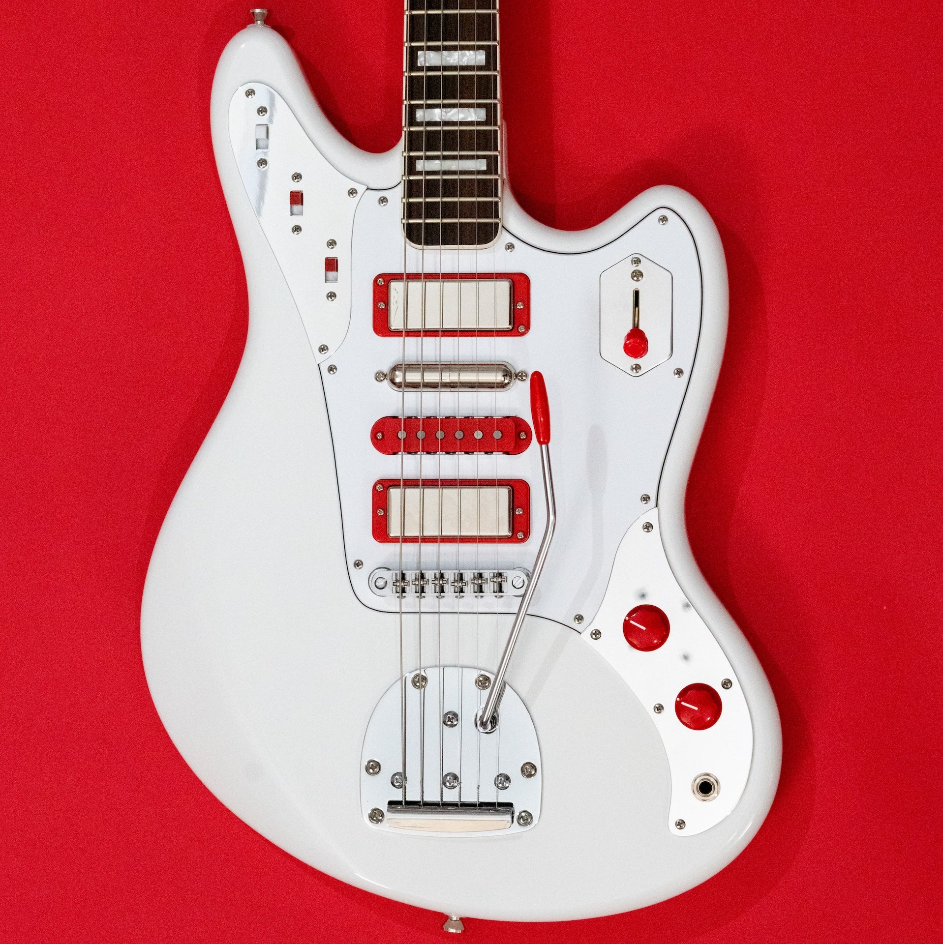 White JHS Relevator electric guitar body with red pickups on a red background